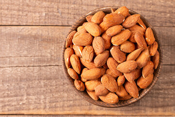 Raw peeled almonds in brown wooden bowl. Organic food concept. 