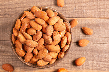 Raw peeled almonds in brown wooden bowl. Organic food concept. 