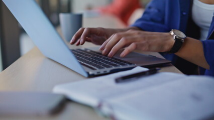 Woman hands writing notebook working laptop at modern coworking space closeup.