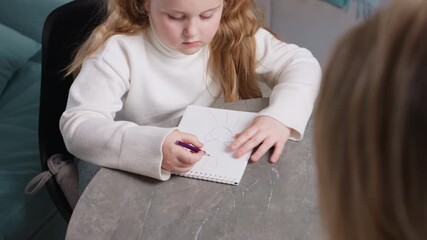 Focused girl drawing with purple pencil in notebook at table, concentrating on sketch, childhood creativity, learning, artistic development, education, imagination, study and artistic expression