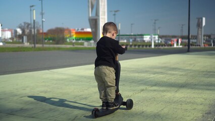 A Happy Child Riding a Bright Scooter in the Open Park, Enjoying an Adventurous Day