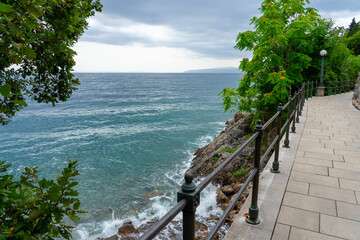 Stone seaside path Lungomare with railing along Adriatic coast in Opatija, Croatia