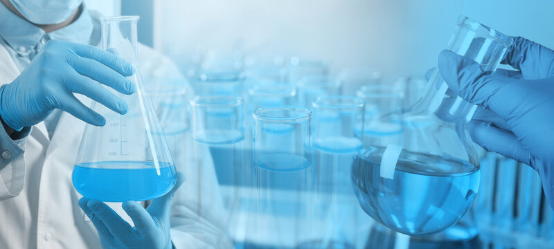 Laboratory analysis. Scientists holding flasks, double exposure with test tubes - Powered by Adobe