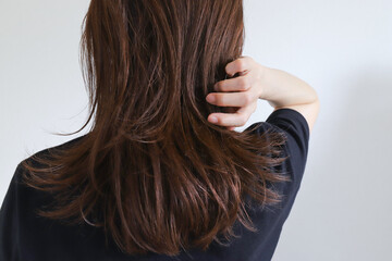 髪の毛を触る女性　ヘアケア