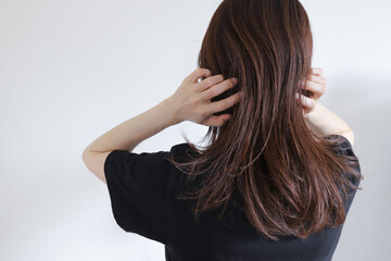 髪の毛を触る女性　ヘアケア