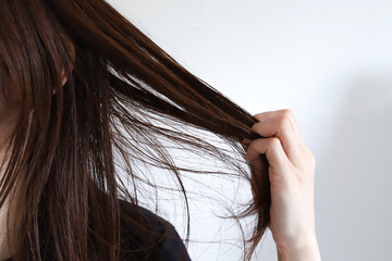 髪の毛を触る女性　ヘアケアイメージ