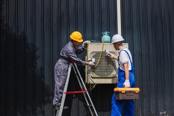 Technicians Working on Air Conditioning Unit, Performing Maintenance and Repairs on Equipment Outdoors