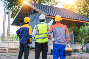 Construction Team Discussions at Building Site with Safety Gear and Tools Observing Progress under Bright Sunlight