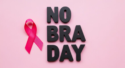 Pink ribbon and bold letters spelling no bra day against a soft pink background
