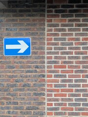 One way exit arrow on a brick wall in a carp park