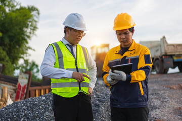 Construction Site Meeting Between Engineer and Supervisor with Safety Gear Under Sunset Sky