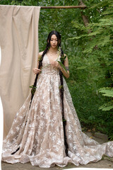 Fototapeta premium Young lady with long hair in floral gown outside.
