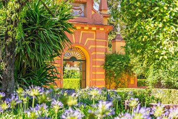 Obraz premium The gardens, flowers and architecture at the Real alcazar de Sevilla or the Royal Alcazar of Seville in Spain. 