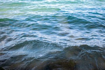 Top down view of calm water surface at Lake Garda turquoise blue water from Sirmione city shoreline
