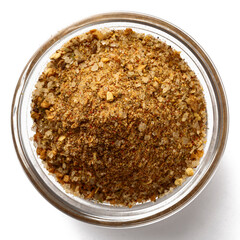 Top view of a glass bowl filled with mixed spices and seasoning blend. Aromatic ground herbs, salt, and powdered spices for cooking, grilling, barbecue, and gourmet recipes.
