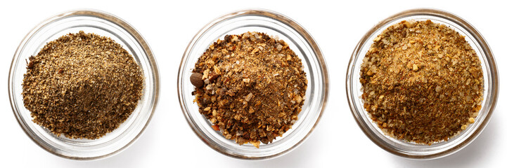 High-quality closeup image of assorted spice blends in three transparent glass bowls on a white background, viewed from above.
