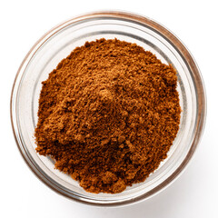 High-quality closeup image of ground cinnamon powder in a transparent glass bowl on a white background, viewed from above.