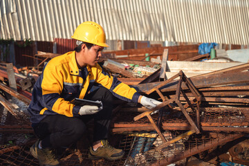 Inspector at Scrap Metal Yard: An inspector, equipped with protective gear, meticulously assesses and documents the quality of metal scrap, highlighting his dedication to responsible recycling.