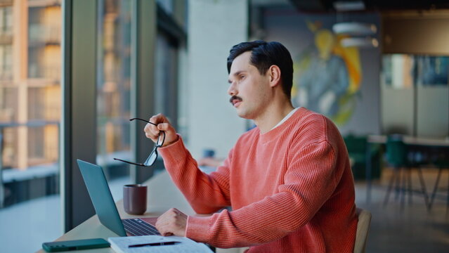 Fototapeta Serious entrepreneur looking solutions sitting office coworking laptop closeup.