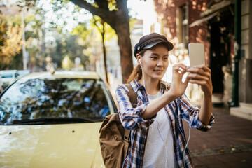 Fototapeta premium Young woman taking a selfie outdoors