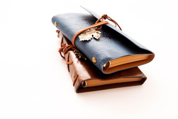 A stack of two vintage leather journals with embossed designs, presented on a white background as a visual concept of travel, creativity, and the collection of memories