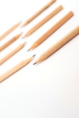 Obraz premium Wooden graphite pencils arranged on white background, minimal stationery concept for writing, sketching, office, school or creative art use, symbol of study, drawing, education, simplicity, and design