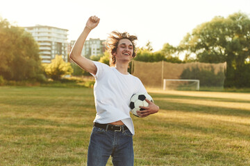 Naklejka premium Smiling, having fun. Man is in the field with soccer ball