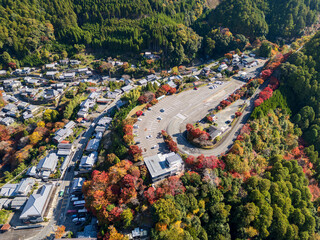 Aerial view of the Arashiyama-Takao Parkway passing over Jingo-ji Temple and village in colorful autumn valley. Takao area, Ukyo Ward, Kyoto, Japan