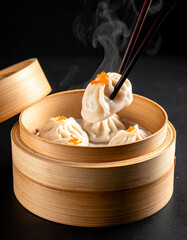 Steamed Soup Dumplings Being Lifted by Chopsticks in Bamboo Steamer