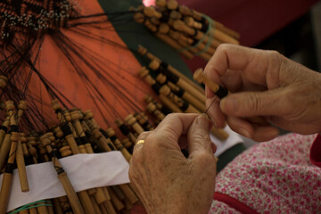 Detail of the hands of a traditional bobbin lacemaker performing her craft.
