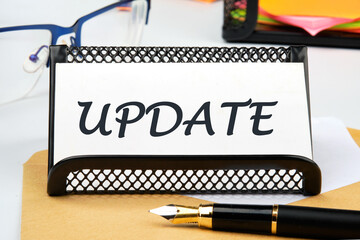 Text UPDATE the inscription on the business card on the table near the pen, a calculator, a stand with a ticker