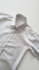 A light gray, long-sleeved collared shirt lies casually on a white surface, its collar neatly folded and buttons visible down the front placket