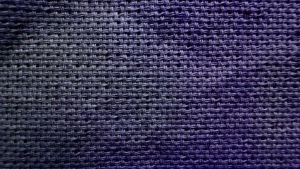 purple woven textile macro with crosshatched fibers and subtle shine creating abstract fabric texture for wallpaper or editorial background