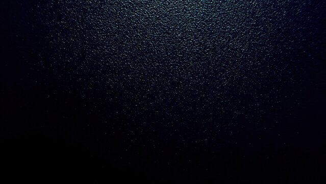 midnight ocean surface glistening with scattered moonlight sparkles for dramatic dark blue abstract wallpaper or elegant banner background