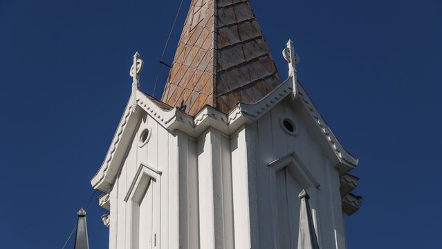 Pointed church tower with wooden elements and clear blue sky in the background, Tangen kirke or church, Olavsweg or Olavsleden, pilgrimage route, Tangen, Stange municipality, Norway