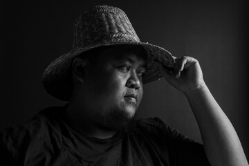 Male profile view with straw hat touching brim, monochrome black and white image, vintage portrait...