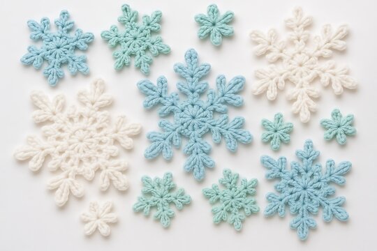Crocheted snowflakes in blue, white, and mint green arranged on a light background for winter crafting inspiration