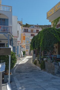 Fototapeta Narrow, vegetation-lined street in the charming Mediterranean fishing village of Diafani, hiking trail from Avlona to Diafani, Avlona, Diafani, Karpathos, Greece