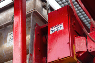 "Pinch point warning sign" hand and finger injury prevention alert that showed on the industrial equipment such as blender, pumping or milling machine. Safety sign in unsafe working place, close-up.