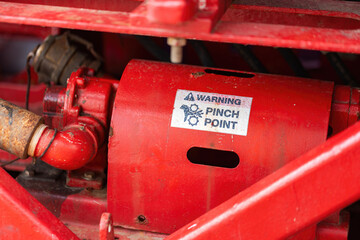 "Pinch point warning sign" hand and finger injury prevention alert that showed on the industrial equipment such as blender, pumping or milling machine. Safety sign in unsafe working place, close-up.