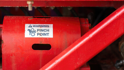 "Pinch point warning sign" hand and finger injury prevention alert that showed on the industrial equipment such as blender, pumping or milling machine. Safety sign in unsafe working place, close-up.