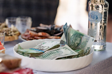 Cash and snacks on a table.  Money in a bowl, ready for a celebration or event.