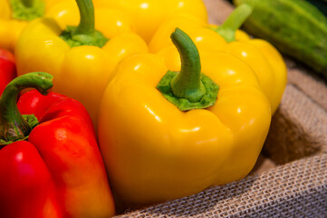 A close-up of several bell peppers. Red and yellow peppers close-up on a store shelf.