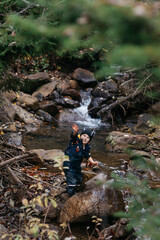 Cute kid enjoying the autumn leaves and rural landscape in a Romanian village. 