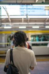 People standing in line at a Japanese train station platform, waiting for a subway train to arrive. Urban transportation, daily commuting, and modern lifestyle concept in Tokyo, Japan
