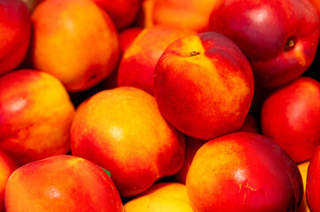 Brightly colored nectarines at the market. A vertical photo of the juicy, fresh fruit