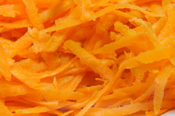 Freshly grated carrots piled together on a kitchen surface ready for cooking or salad preparation