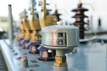 Oil temperature gauge on power distribution transformer in electrical substation