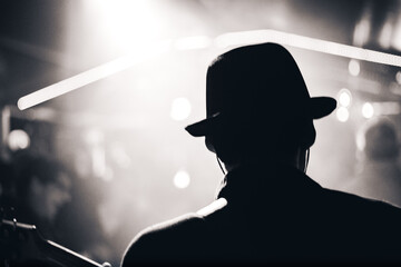 musician silhouette performing on stage in dramatic lighting