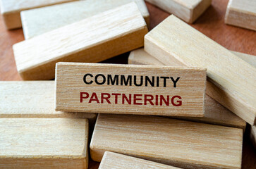 Community partnering text written on wooden blocks representing collective action for social development.